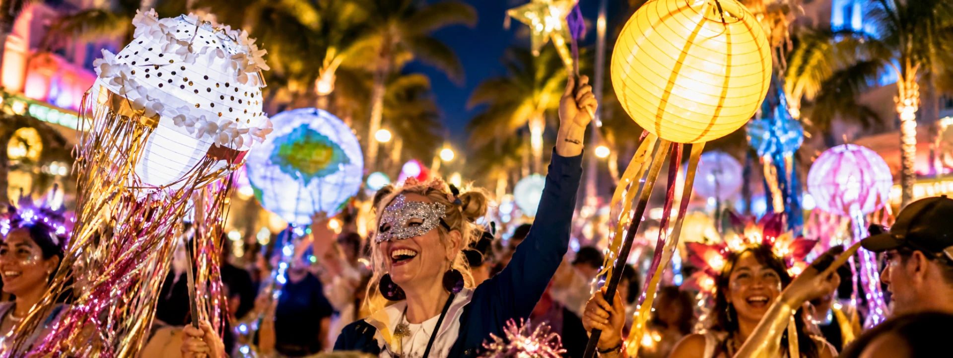 Joyful paraders in masks raise glowing jellyfish and paper lanterns under palm trees at night